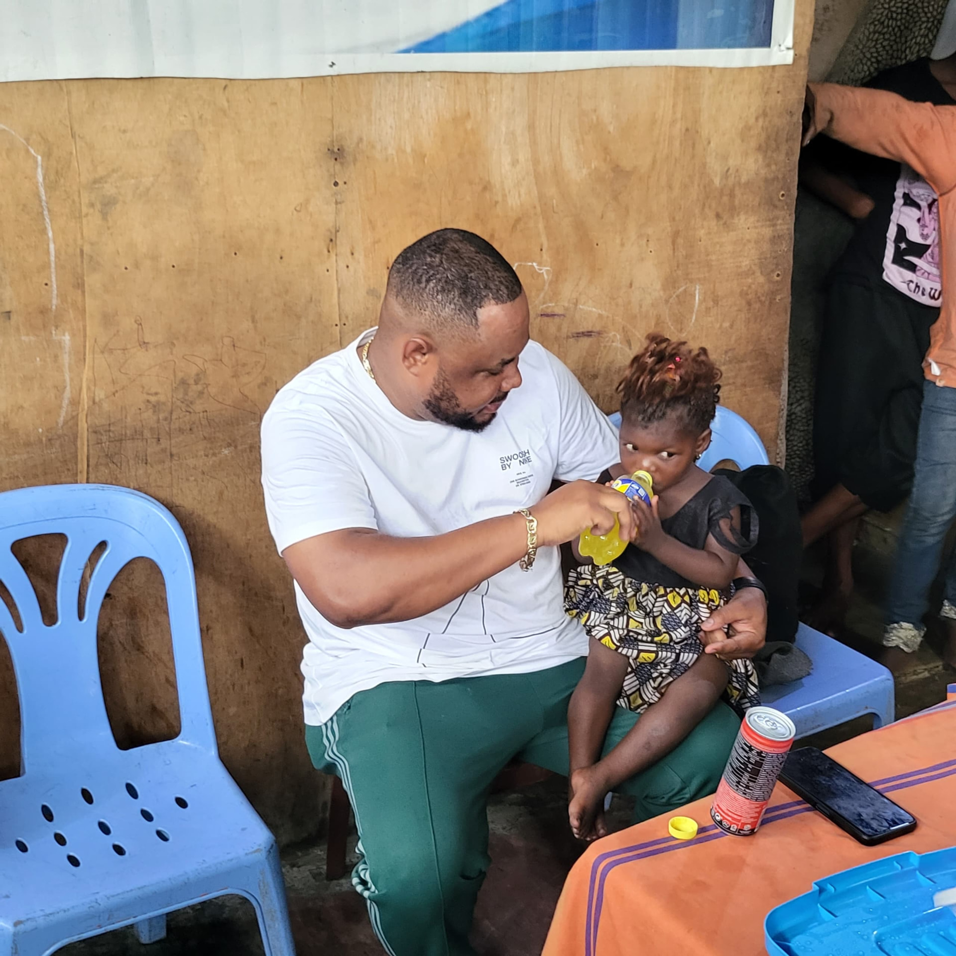 Un membre de la fondation donnant à boire à une petite fille